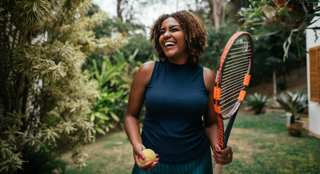 Woman with tennis racket enjoys the outdoors. In midlife, the sun is not a reliable source of vitamin D and comes with the risk of skin cancer. 