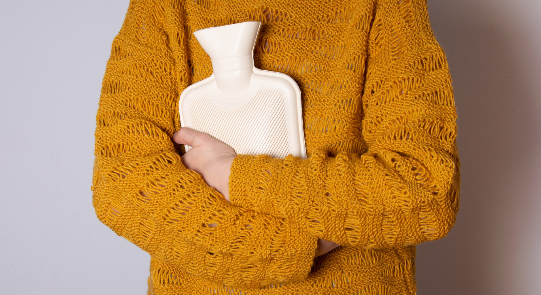 Irregular Bleeding in Perimenopause: Woman with hot water bottle over abdomen 